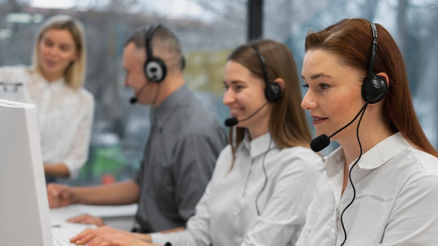 Call center agents wearing headsets and working efficiently using call center software in a modern office environment